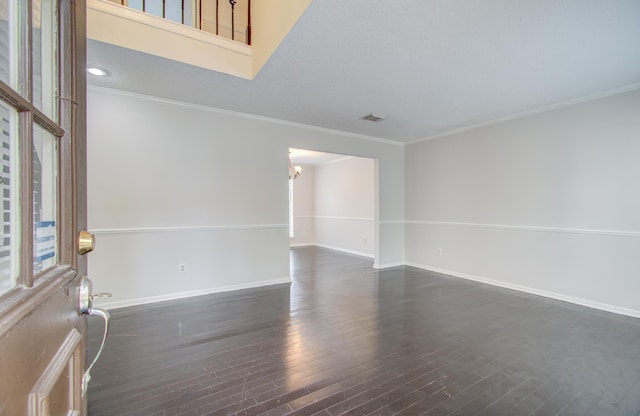 spare room featuring a textured ceiling, dark hardwood / wood-style flooring, and crown molding