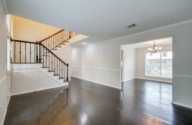 unfurnished living room with a chandelier, a textured ceiling, dark hardwood / wood-style floors, and ornamental molding