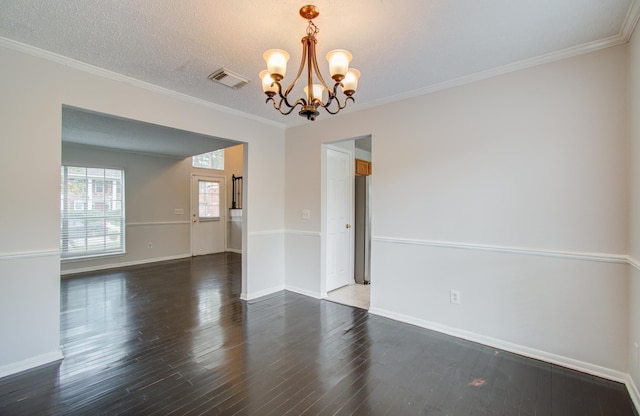 spare room featuring a chandelier, dark hardwood / wood-style floors, and crown molding