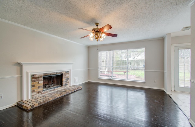 unfurnished living room with a textured ceiling, dark hardwood / wood-style floors, a brick fireplace, and crown molding