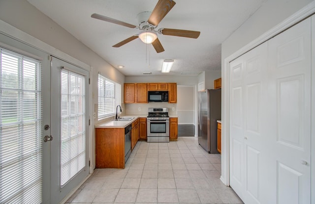 kitchen featuring ceiling fan, french doors, sink, stainless steel appliances, and light tile patterned floors