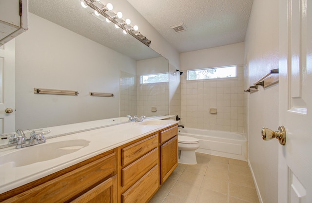 full bathroom featuring tile patterned flooring, a textured ceiling, toilet, vanity, and tiled shower / bath