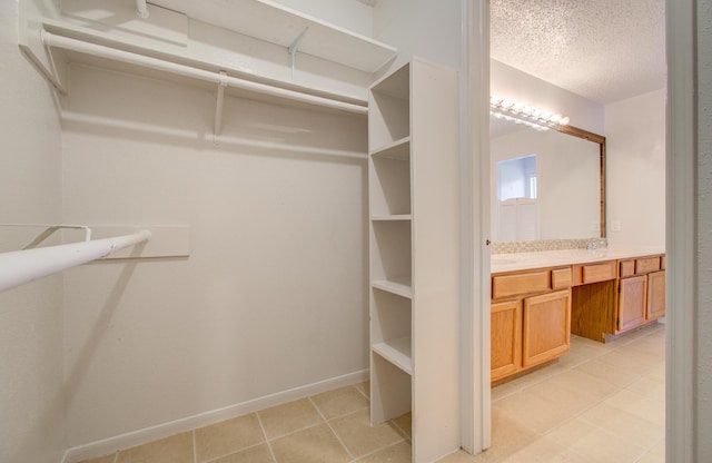 walk in closet with light tile patterned floors