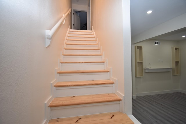 staircase with hardwood / wood-style flooring