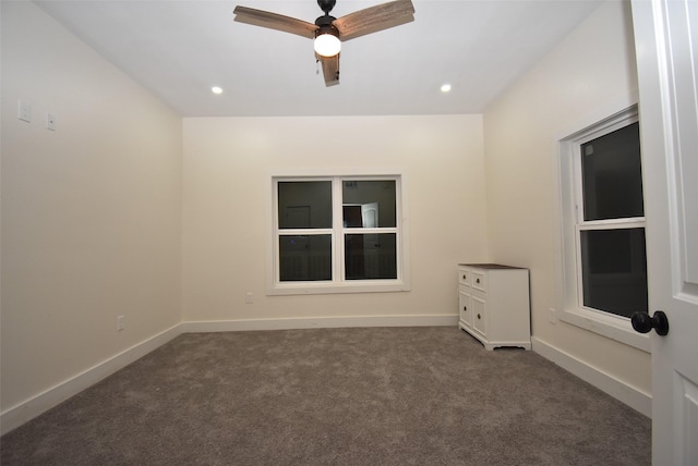 empty room featuring dark carpet and ceiling fan