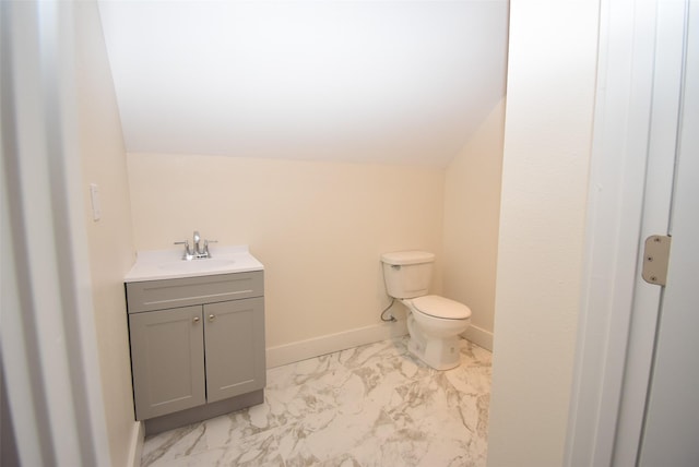 bathroom featuring vanity, vaulted ceiling, and toilet