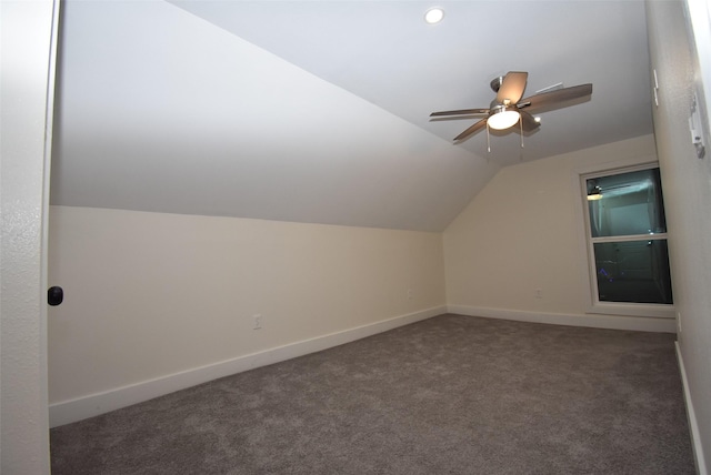 additional living space with dark colored carpet, ceiling fan, and lofted ceiling