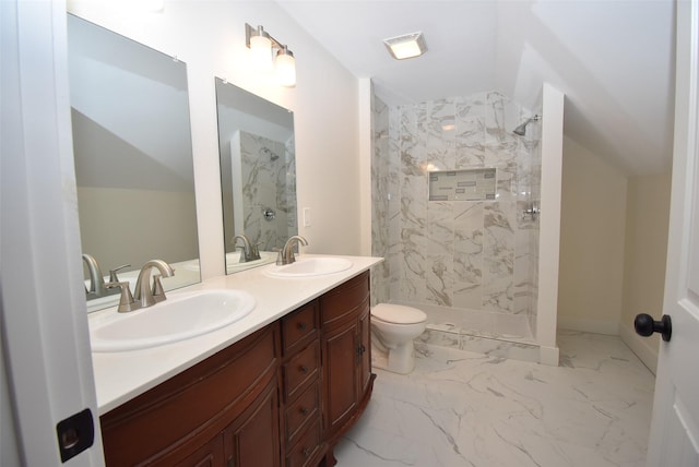 bathroom with vanity, toilet, and tiled shower