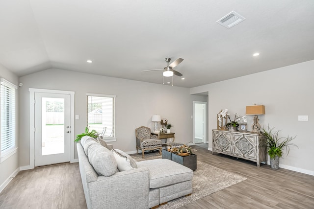 living room featuring a wealth of natural light, ceiling fan, vaulted ceiling, and light wood-type flooring