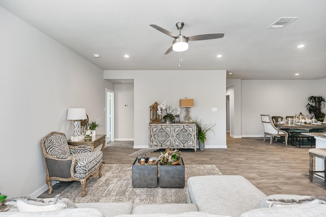 living room featuring ceiling fan and hardwood / wood-style floors