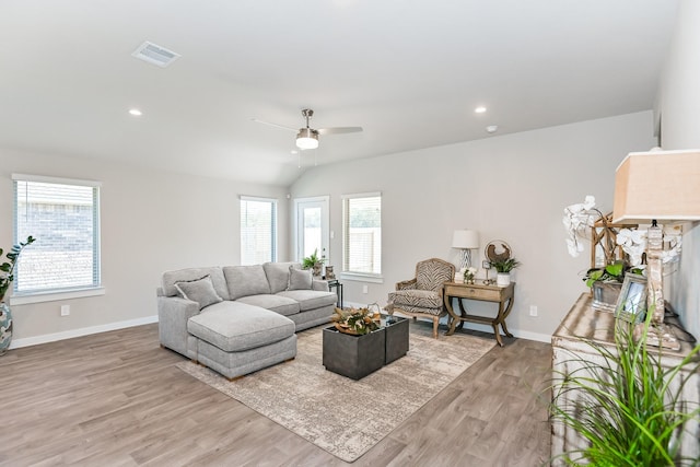 living room with a fireplace, vaulted ceiling, light hardwood / wood-style flooring, and ceiling fan