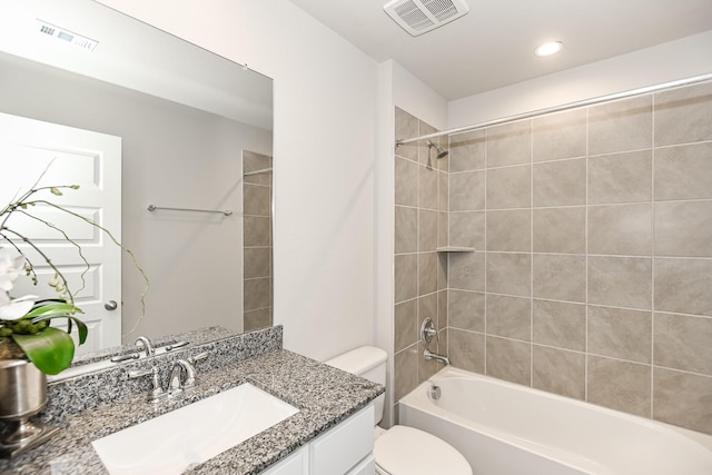 full bathroom featuring tiled shower / bath combo, toilet, and vanity