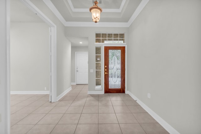 foyer entrance featuring light tile patterned floors, a tray ceiling, and ornamental molding