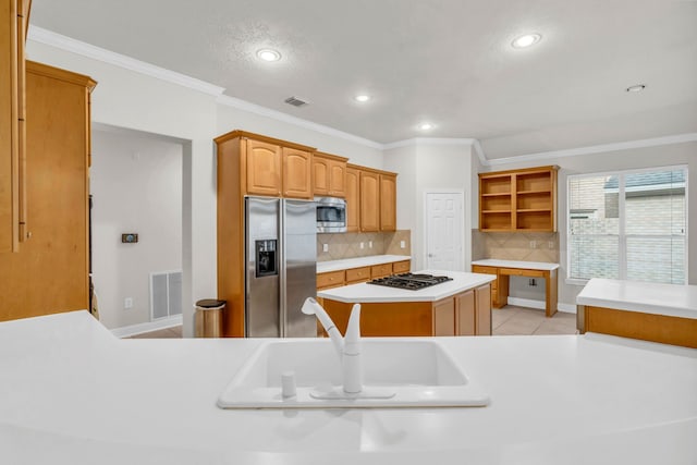 kitchen featuring stainless steel appliances, crown molding, sink, light tile patterned floors, and a center island