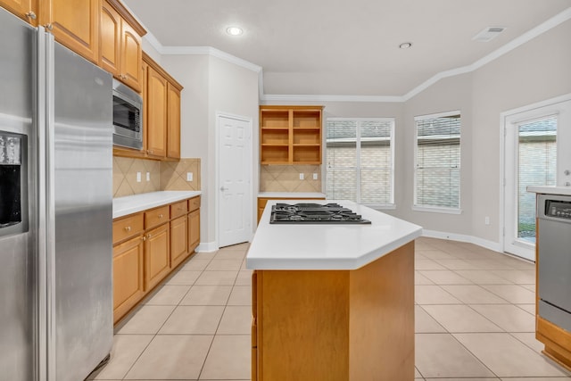 kitchen with decorative backsplash, appliances with stainless steel finishes, light tile patterned floors, and a kitchen island