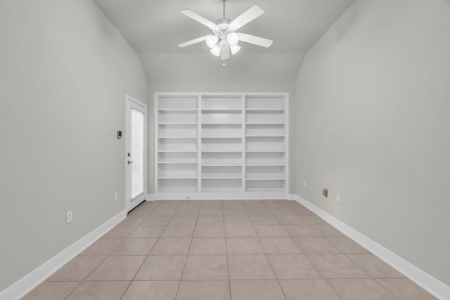 tiled spare room with ceiling fan and vaulted ceiling