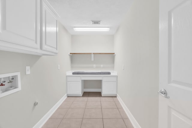 washroom featuring cabinets, hookup for a washing machine, a textured ceiling, and light tile patterned flooring