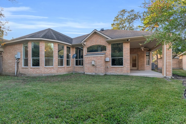 back of property with ceiling fan, cooling unit, a patio area, and a lawn