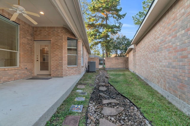 view of yard featuring a patio area, ceiling fan, and central AC unit