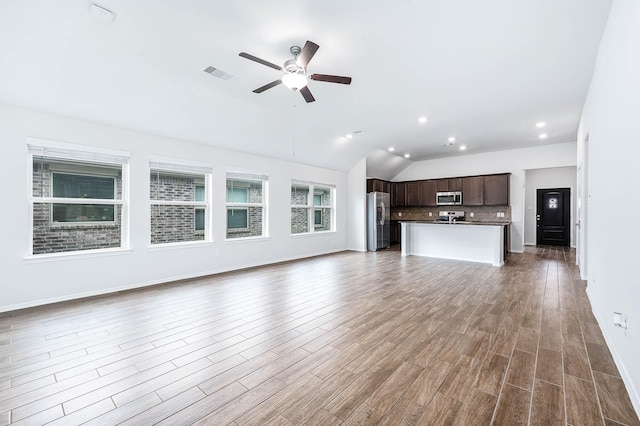 unfurnished living room featuring hardwood / wood-style floors, ceiling fan, and vaulted ceiling