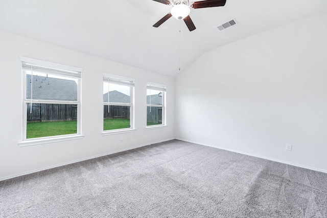 spare room featuring carpet flooring, vaulted ceiling, and ceiling fan