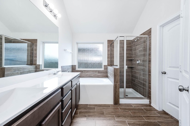 bathroom with shower with separate bathtub, vanity, and lofted ceiling