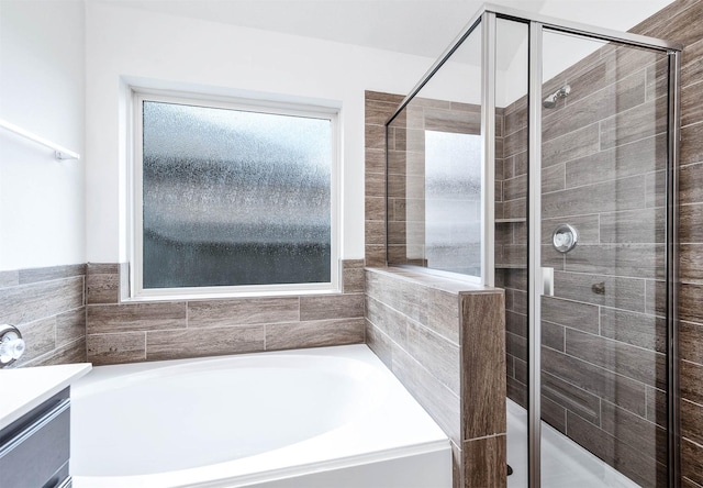 bathroom featuring shower with separate bathtub and vanity