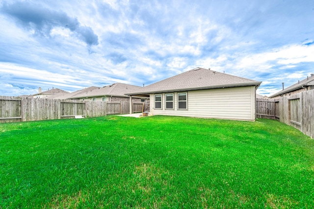 rear view of property featuring a yard and a patio