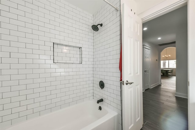 bathroom with hardwood / wood-style flooring and tiled shower / bath