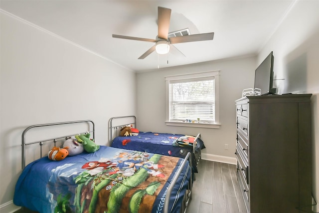 bedroom featuring dark wood-type flooring, ceiling fan, and ornamental molding