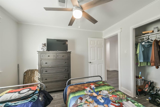 bedroom with ceiling fan, crown molding, and a closet