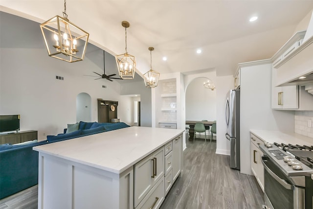 kitchen with pendant lighting, white cabinets, ceiling fan, appliances with stainless steel finishes, and tasteful backsplash