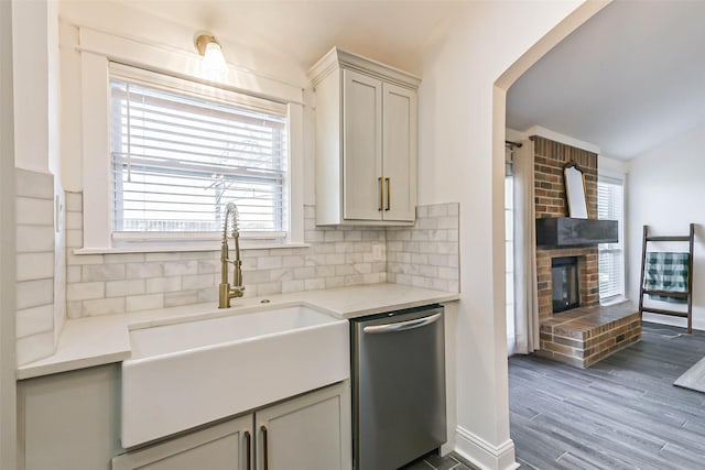 kitchen featuring backsplash, a healthy amount of sunlight, sink, and stainless steel dishwasher