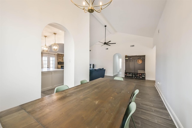 unfurnished dining area with ceiling fan with notable chandelier, french doors, vaulted ceiling with beams, and dark hardwood / wood-style floors