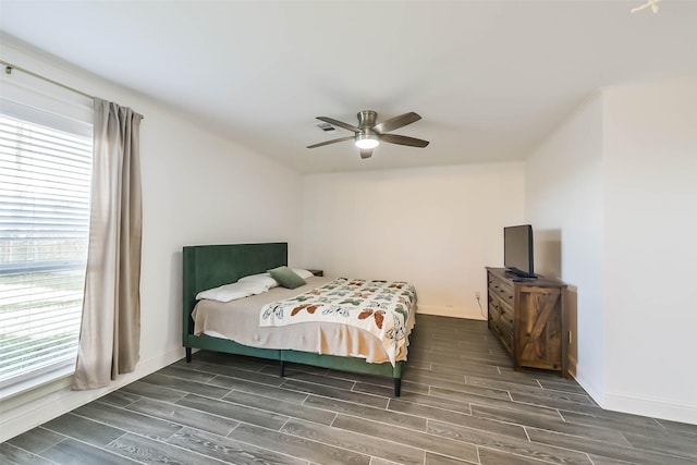 bedroom featuring multiple windows, dark hardwood / wood-style flooring, and ceiling fan