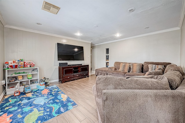 living room with ornamental molding, wood walls, and light wood-type flooring