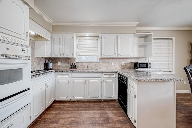 kitchen with white cabinetry, decorative backsplash, stainless steel gas cooktop, light stone counters, and white oven