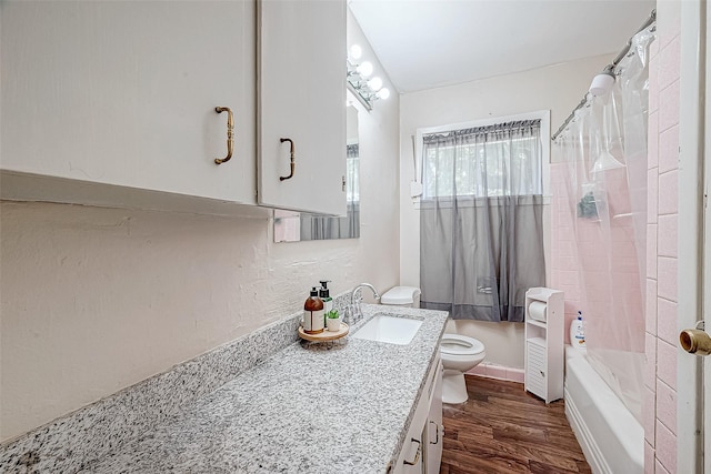 full bathroom with hardwood / wood-style flooring, shower / tub combo with curtain, vanity, and toilet