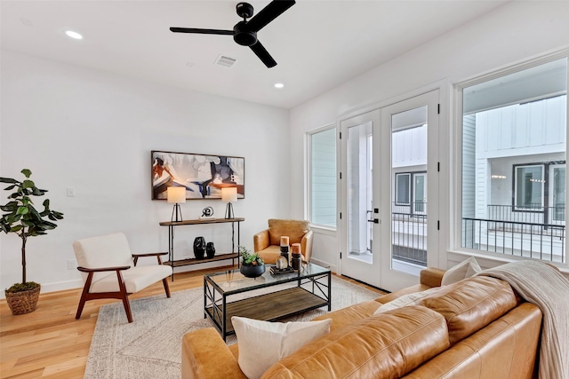 living room featuring ceiling fan, french doors, and light hardwood / wood-style floors