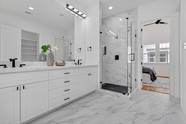 bathroom featuring built in shelves, ceiling fan, and a shower with shower door