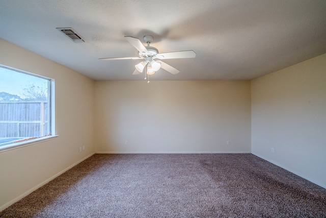 spare room with ceiling fan and carpet