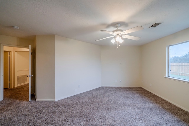 carpeted empty room featuring ceiling fan and a textured ceiling