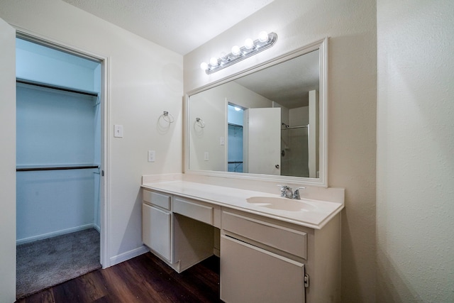 bathroom with vanity, wood-type flooring, and a textured ceiling