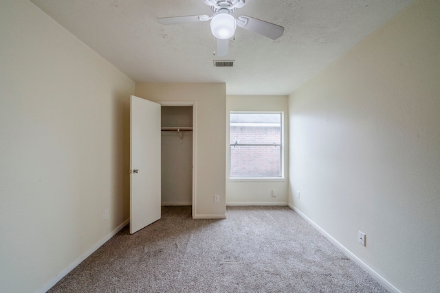 unfurnished bedroom featuring a closet, light colored carpet, and ceiling fan