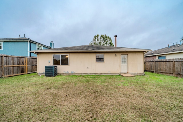 back of property with a lawn and central AC