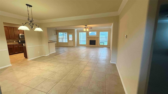 interior space featuring ceiling fan with notable chandelier, light tile patterned floors, and crown molding