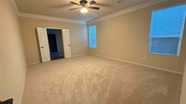 spare room featuring ceiling fan, ornamental molding, and light carpet