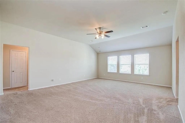 empty room with light carpet, ceiling fan, and vaulted ceiling