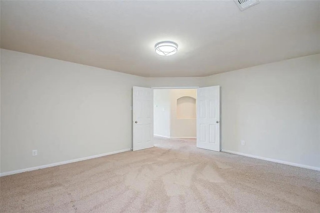 spare room featuring light carpet