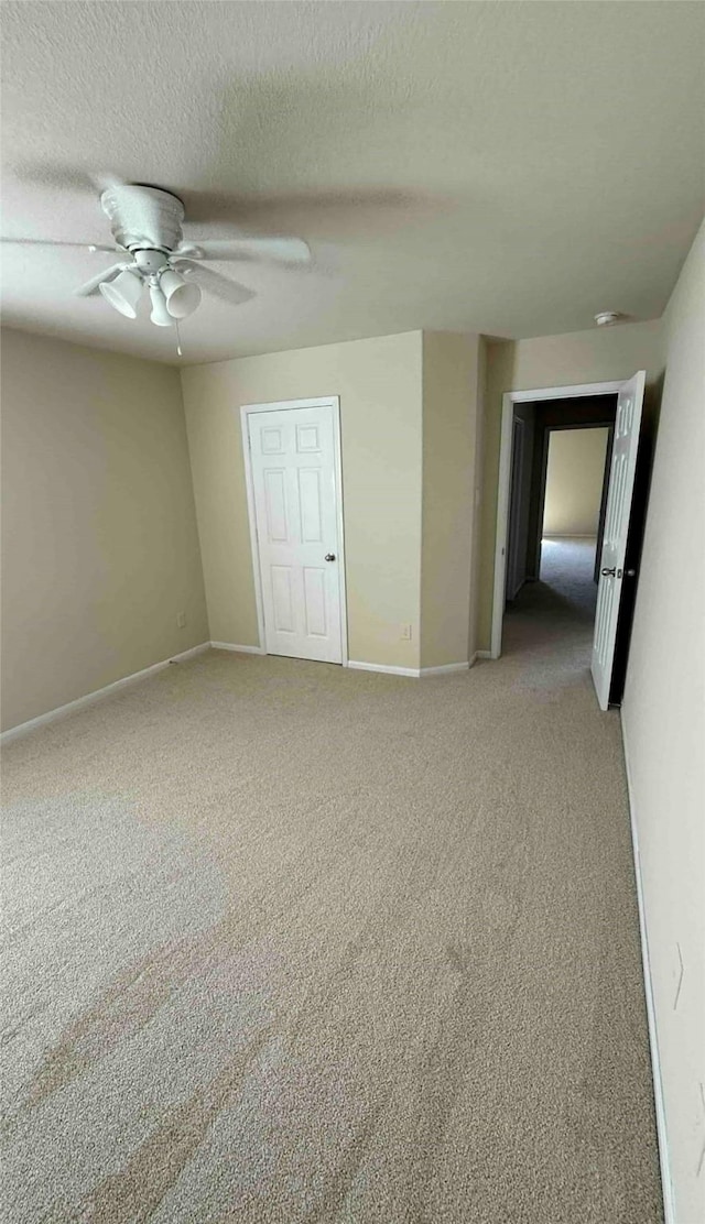 spare room featuring carpet flooring, ceiling fan, and a textured ceiling